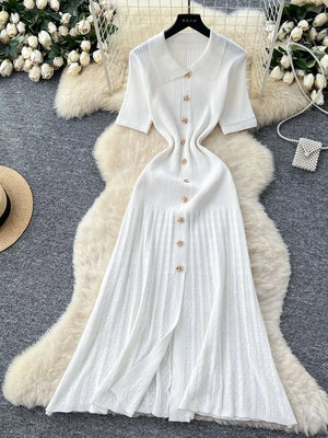 White knit dress with Peter Pan collar, short sleeves, and gold button details.
