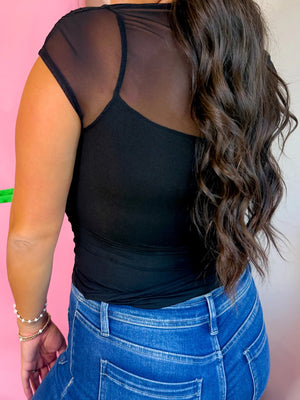 Black sheer mesh cap sleeve t-shirt with a cami overlay, styled with denim jeans.