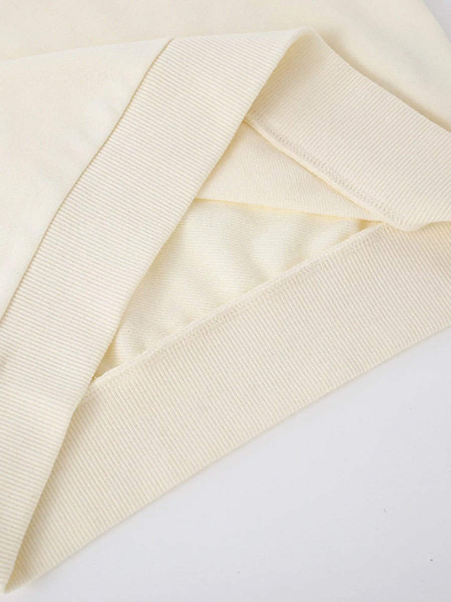Cream crew-neck sweatshirt detail showing ribbed cuffs and hem.