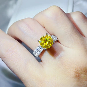 Yellow moissanite pavé band ring with a large center stone on a hand.