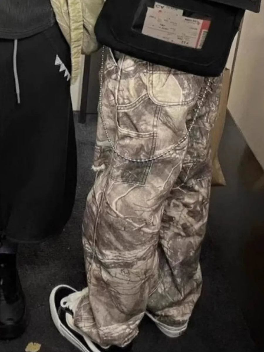 Carpenter jeans in Real Tree camo with raw hem and chain detail.