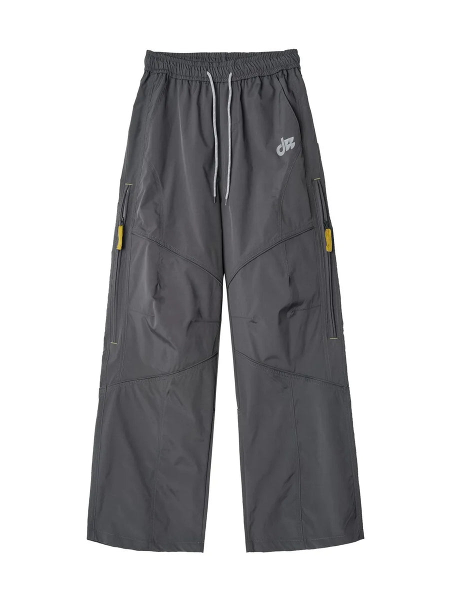 Graphite gray relaxed fit cargo pants with drawstring and yellow zipper accents.
