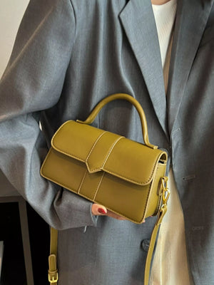 Chic small top handle bag in green with a classic flap closure and gold hardware.