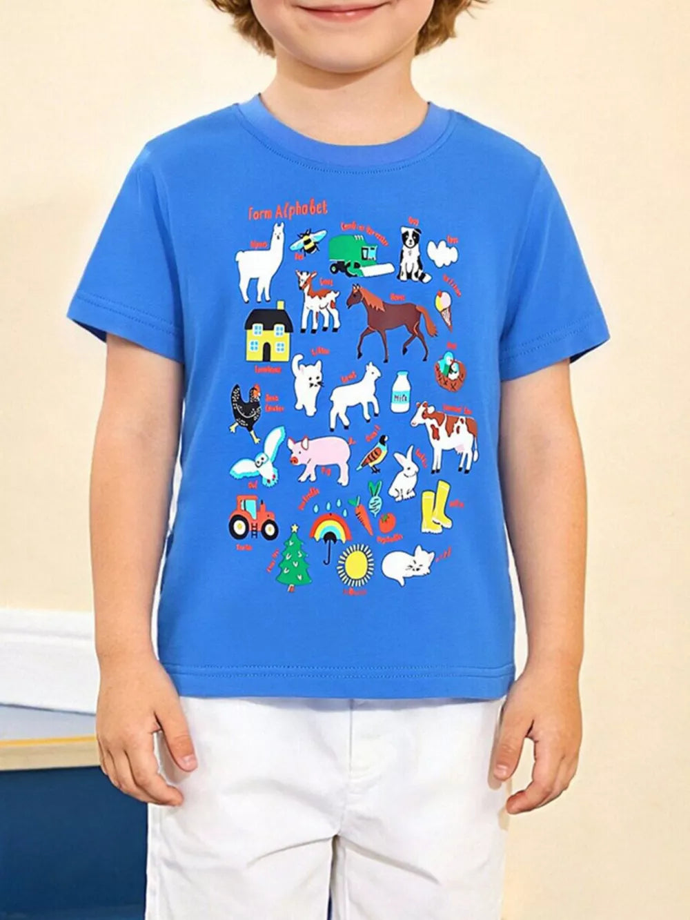 Blue t-shirt with a playful farm alphabet graphic featuring animals, a house, and a tractor.
