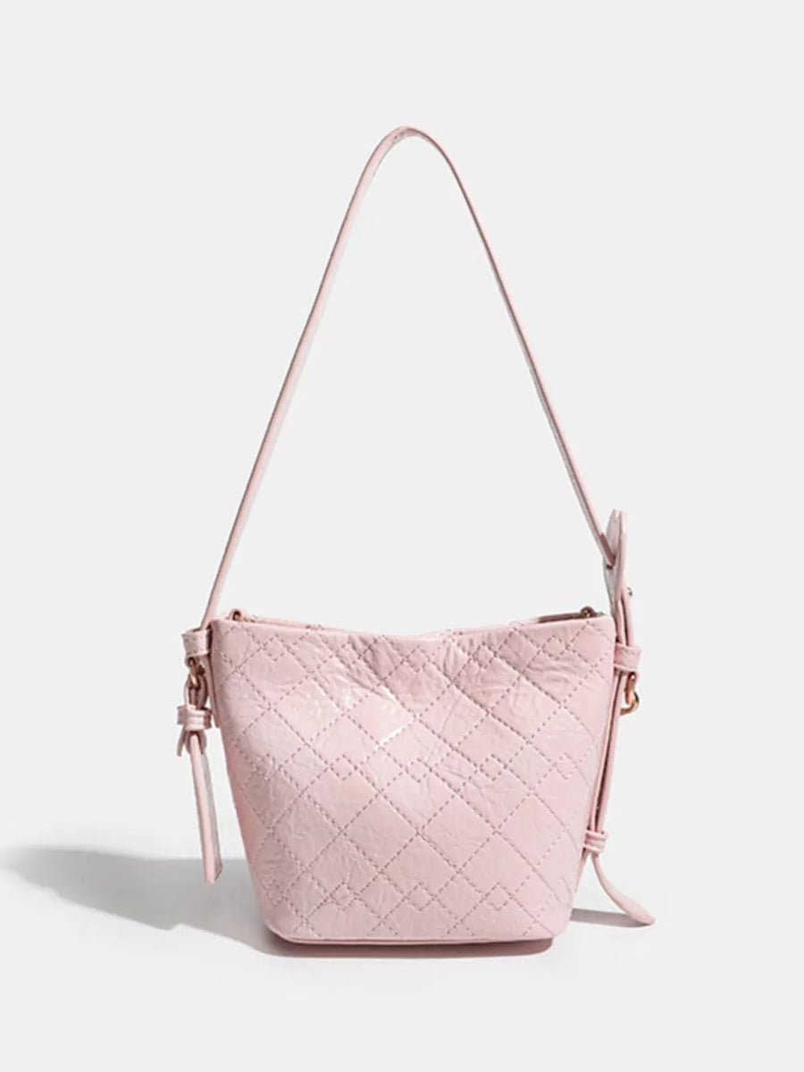 Pink quilted bucket bag with chain accent and adjustable strap