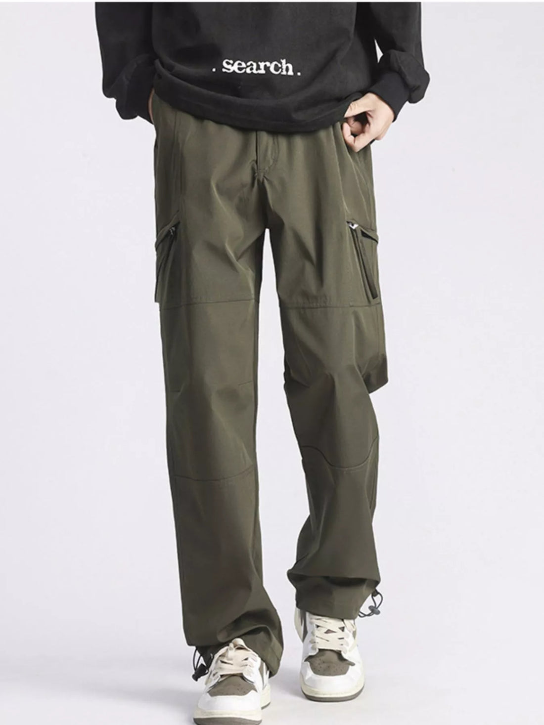 Relaxed fit green cargo pants with multiple pockets and drawstring ankles.