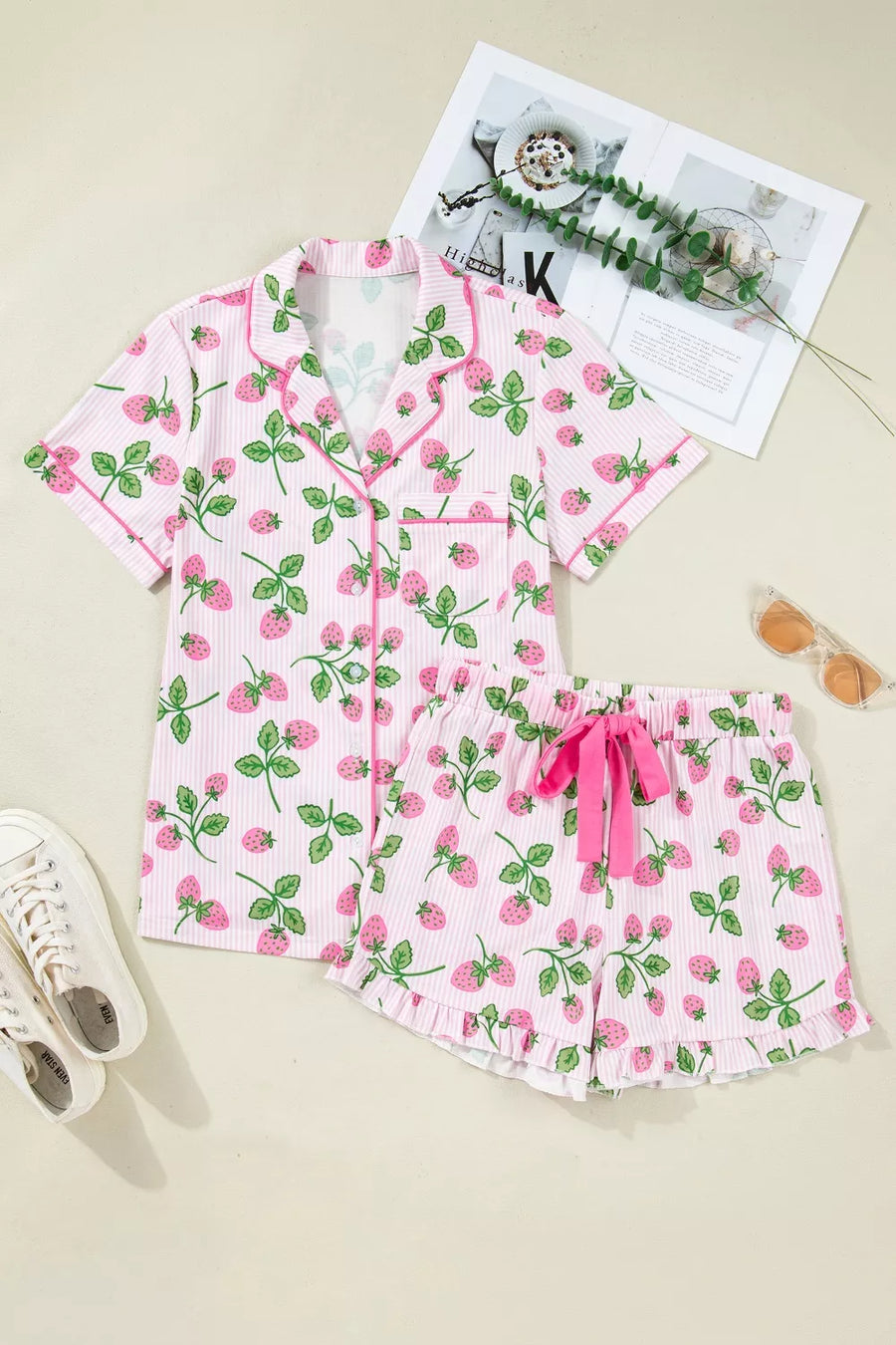 Pink striped pajama set with strawberry print, button-up top, and ruffled shorts with drawstring.