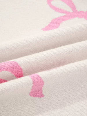 Beige acrylic blend sweater with a pink bow print and a soft knit texture.