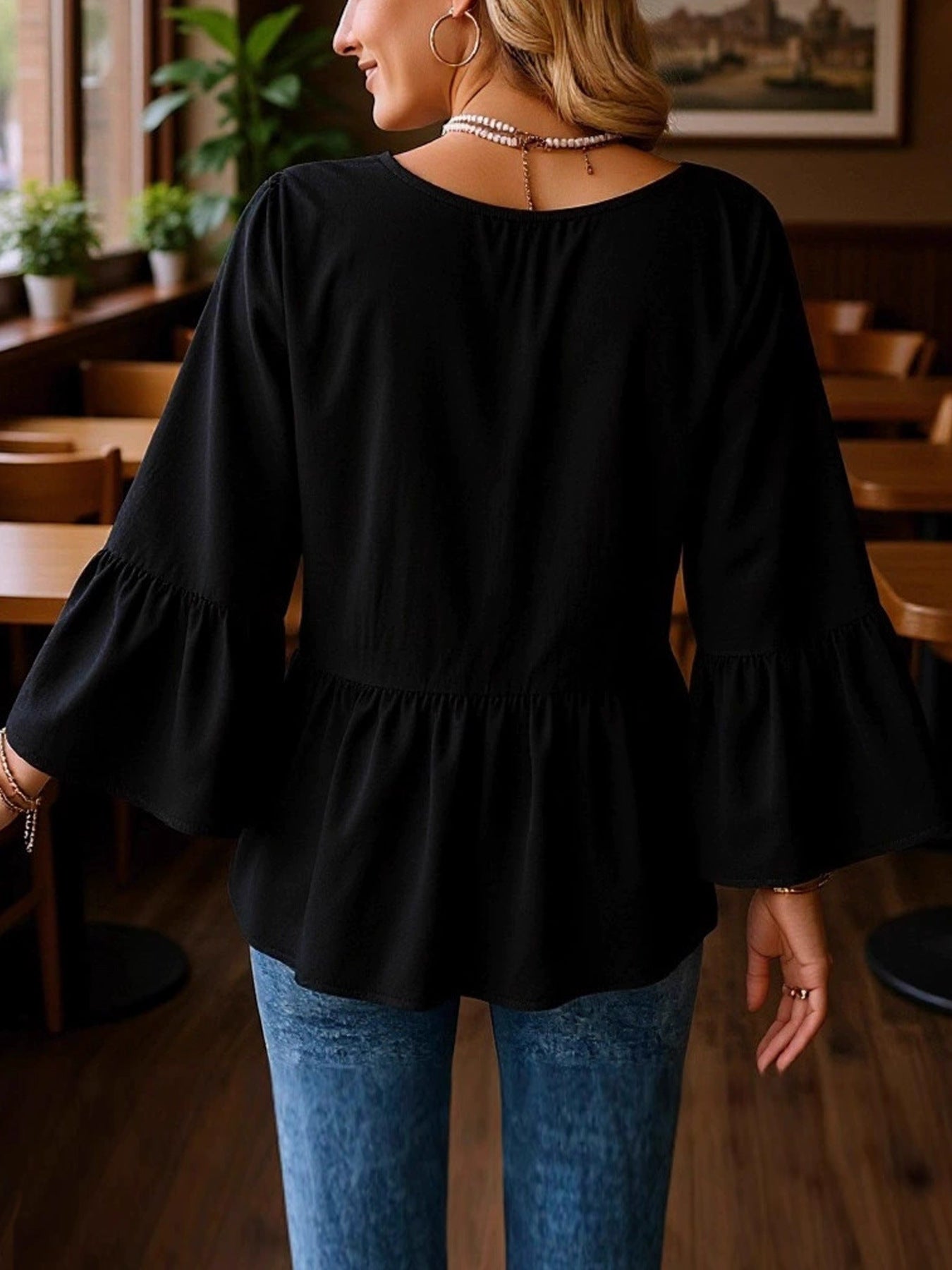 Black v-neck blouse with flounce sleeves and peplum hem
