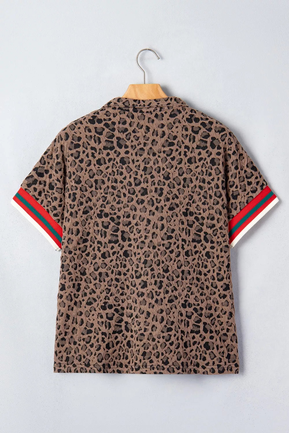 Brown leopard jacquard half-zip shirt with striped sleeve cuffs.