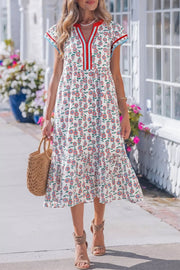 Vibrant floral tiered midi dress with V-neck and short sleeves, made of cotton.