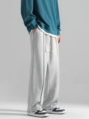 Grey casual drawstring sweatpants with a loose fit and contrast stitching.