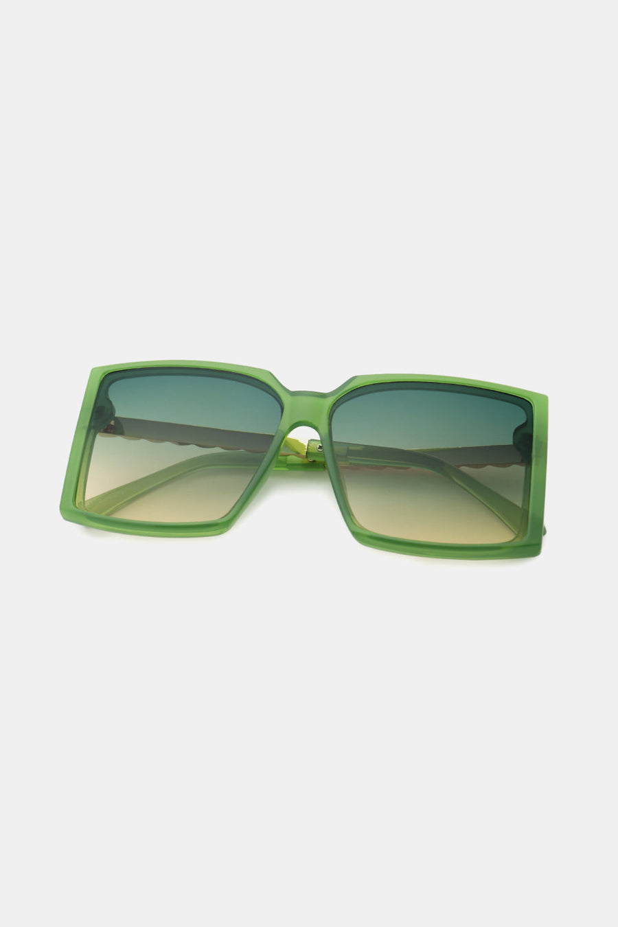 Green geometric sunglasses with gradient lenses and a bold square frame.