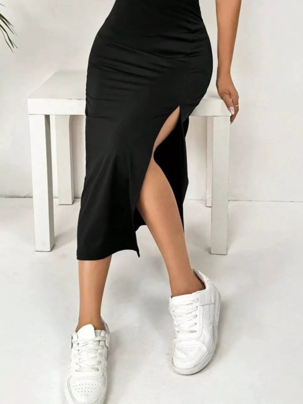 Black spaghetti strap midi dress with ruched side detail and high slit.