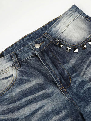 Blue distressed bootcut jeans with studded accents on the waistband.