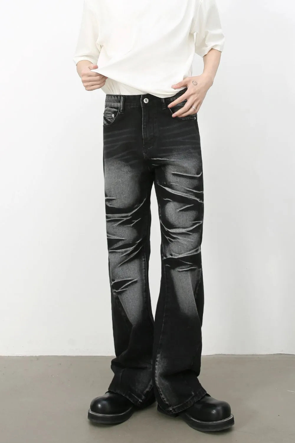 Distressed flare jeans in dark shadow wash denim with a bootcut leg.