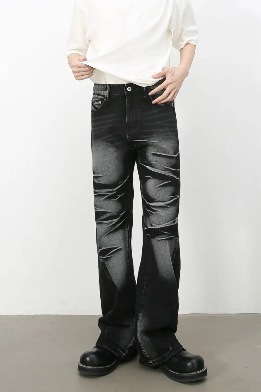 Distressed flare jeans in dark shadow wash denim with a bootcut leg.
