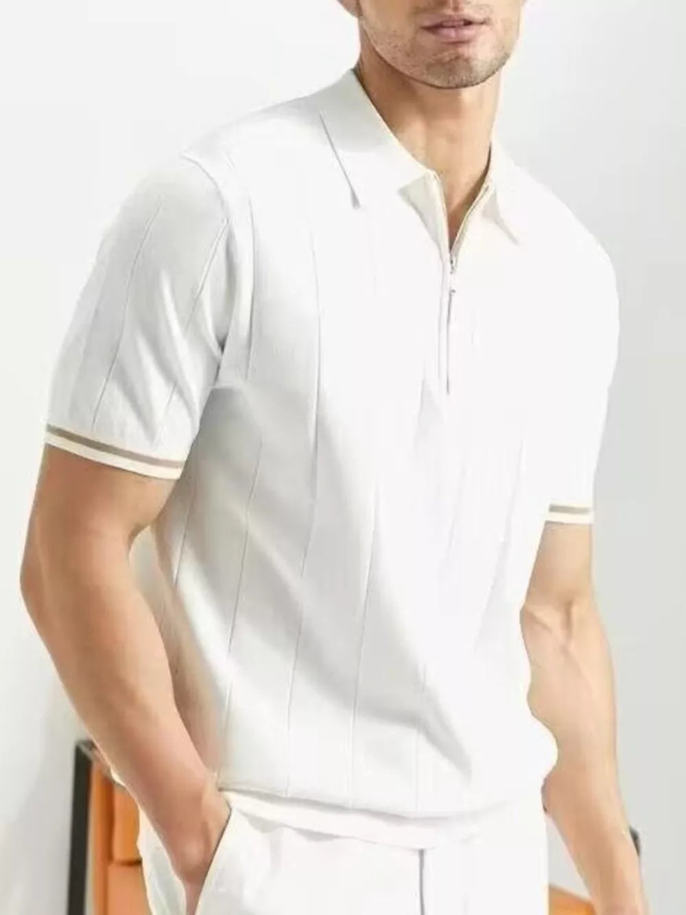 White cotton quarter-zip polo shirt with vertical ribbing and striped cuffs.