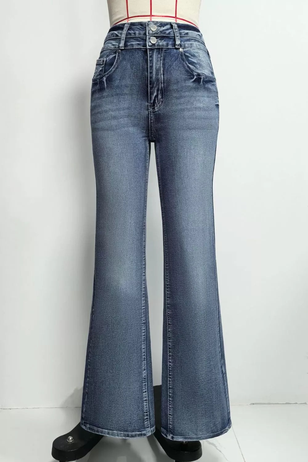 Classic high-waisted flare jeans in blue denim with distressed details and button closure.