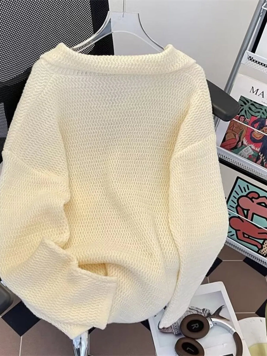 Textured knit polo collar sweater in apricot with a relaxed fit and long sleeves.