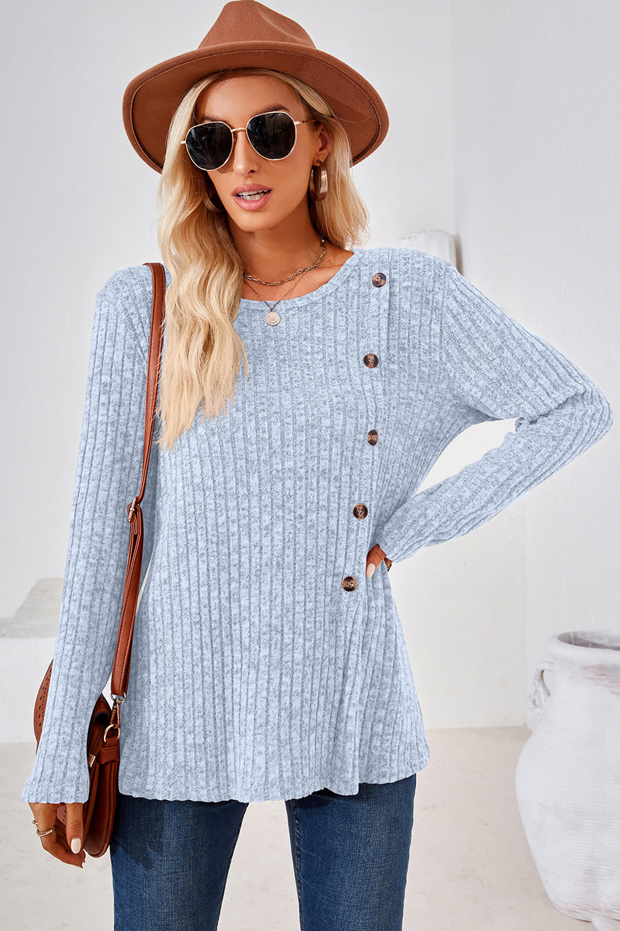 Light blue ribbed knit sweater with asymmetric button detail and crew neck.