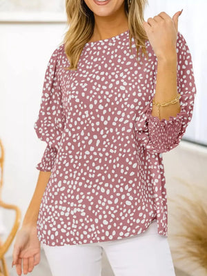 Pink animal print blouse with half sleeves and smocked cuffs.