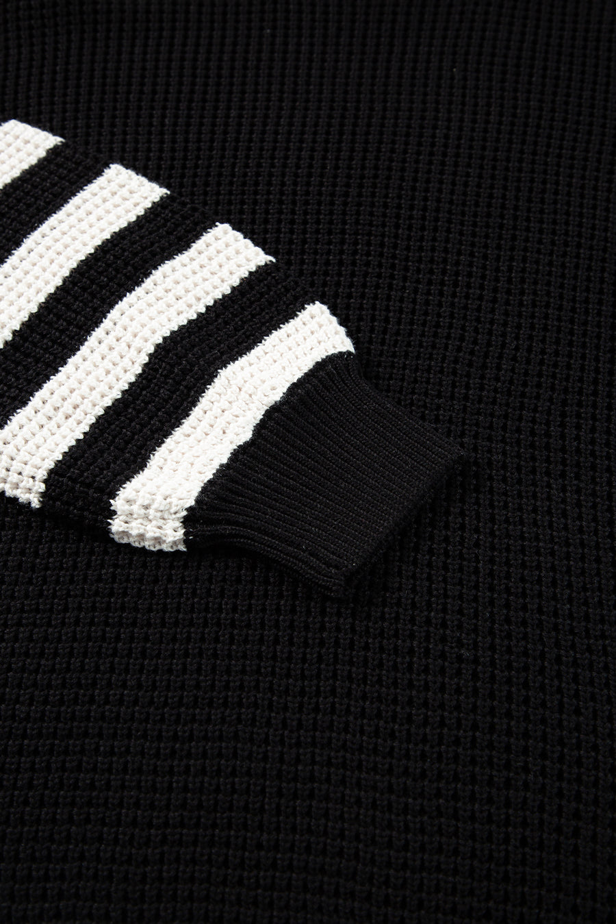 Black knit turtleneck sweater with white stripe sleeves