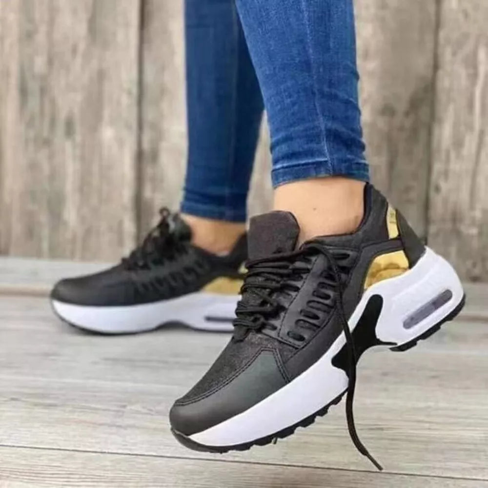 Black lace-up chunky platform sneakers with gold accents and white soles.