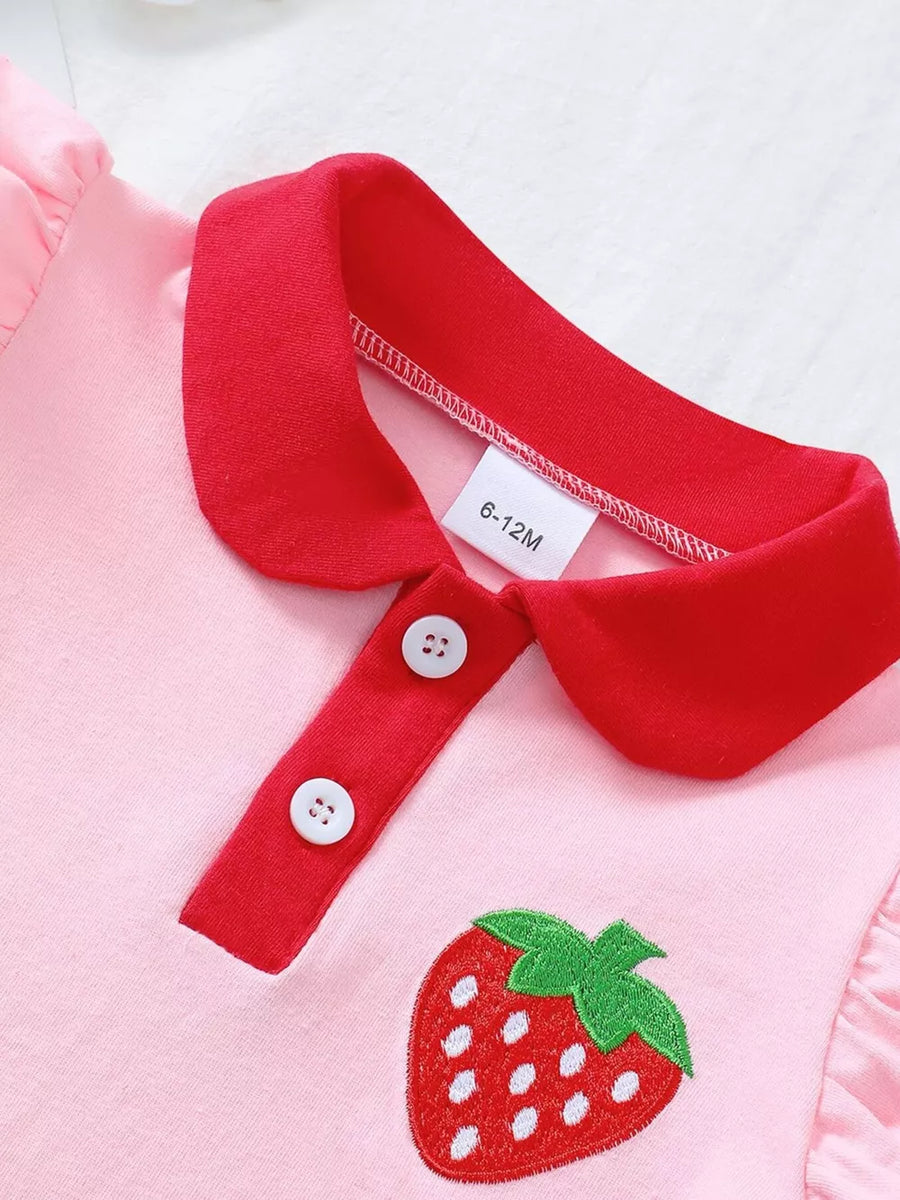 Pink cotton polo top with red collar, strawberry embroidery, and white buttons.