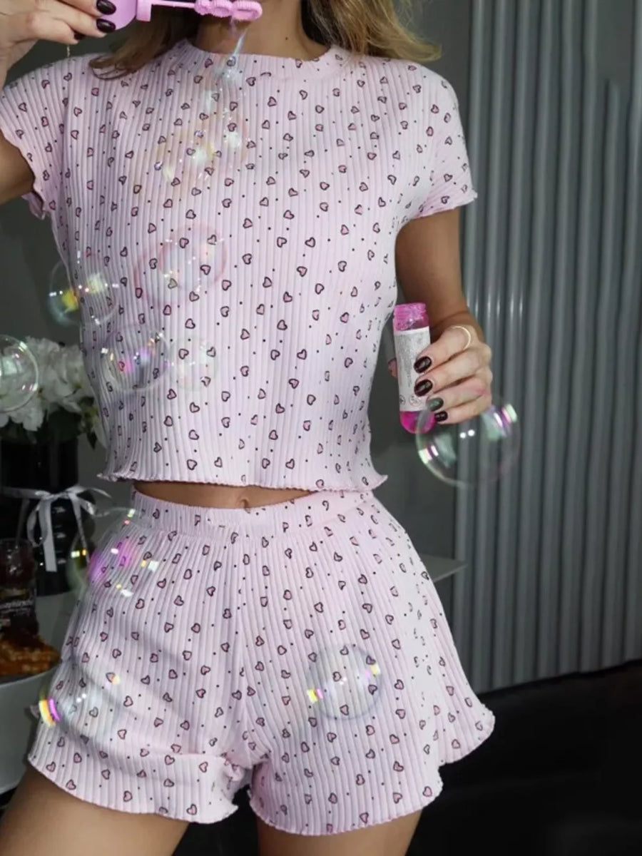Pink heart print ribbed lounge set with cropped top and ruffled shorts.