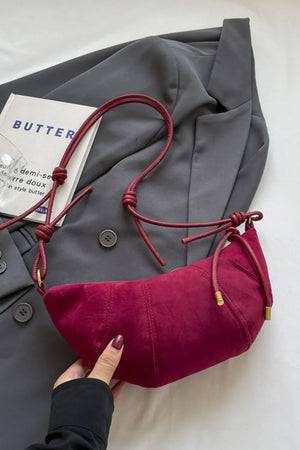 Cerise crescent shoulder bag with knot detail and suede finish
