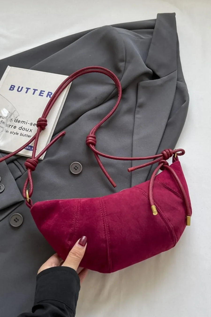 Cerise crescent shoulder bag with knot detail and suede finish