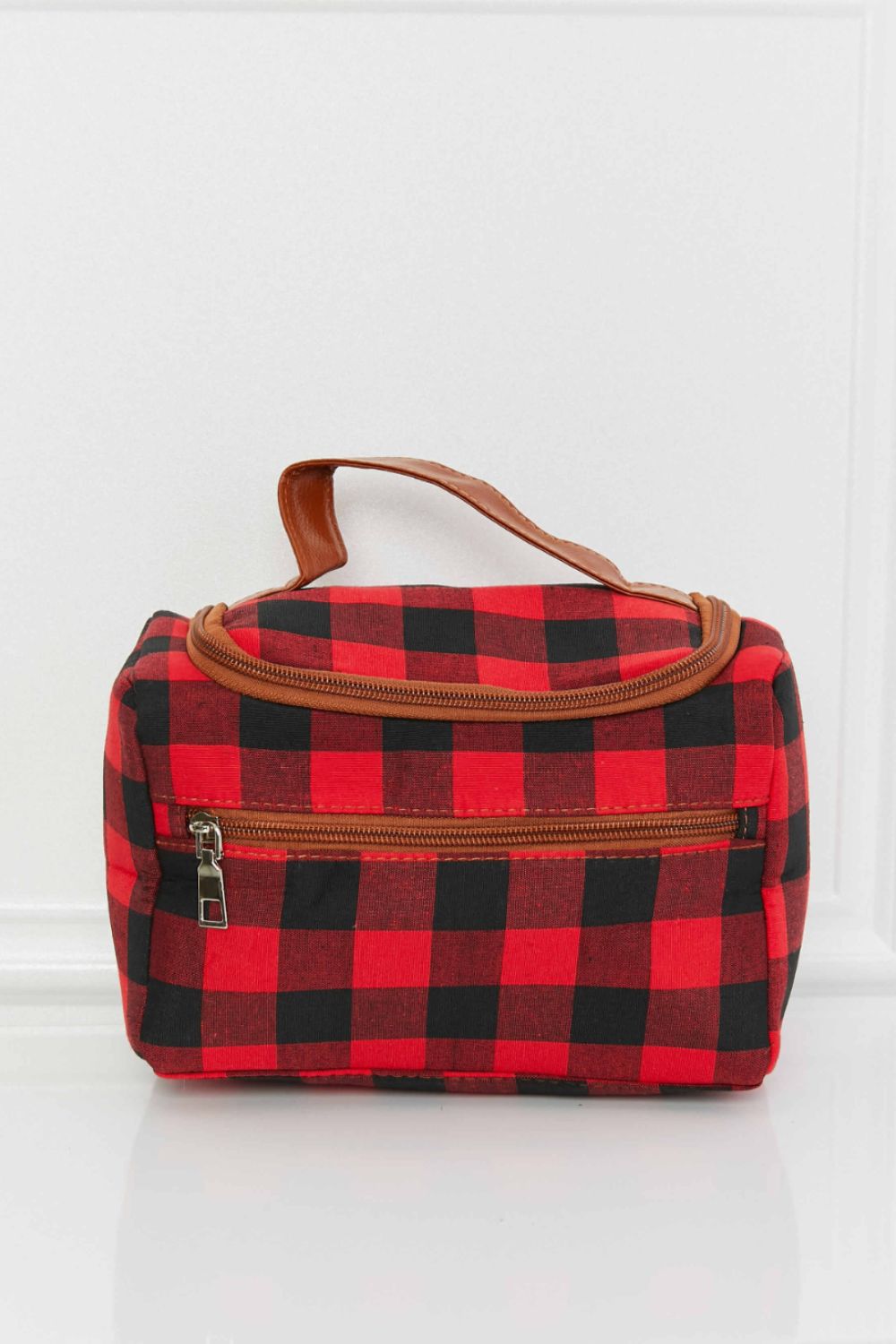 Red and black buffalo check travel case with faux leather handle and zipper pockets.