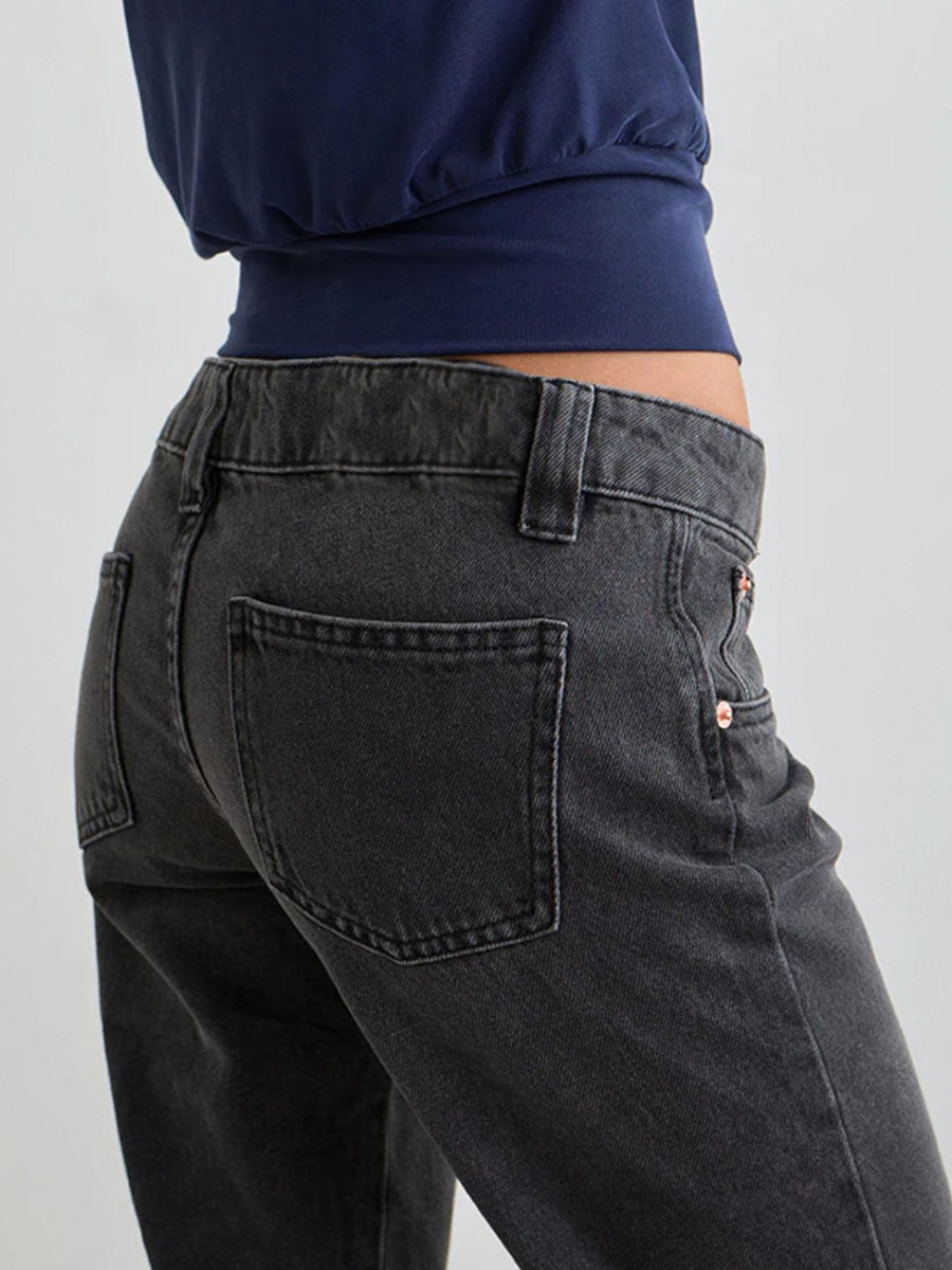 Dark gray low rise flare leg jeans with pockets shown from the back.
