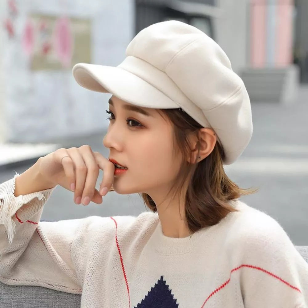 Beige polyester beret with a classic shape and visor, worn by a woman.