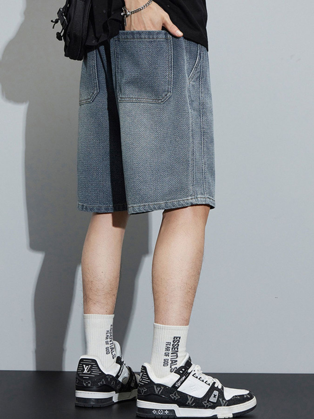 Men's light blue loose fit denim shorts with drawstring and large front pockets.