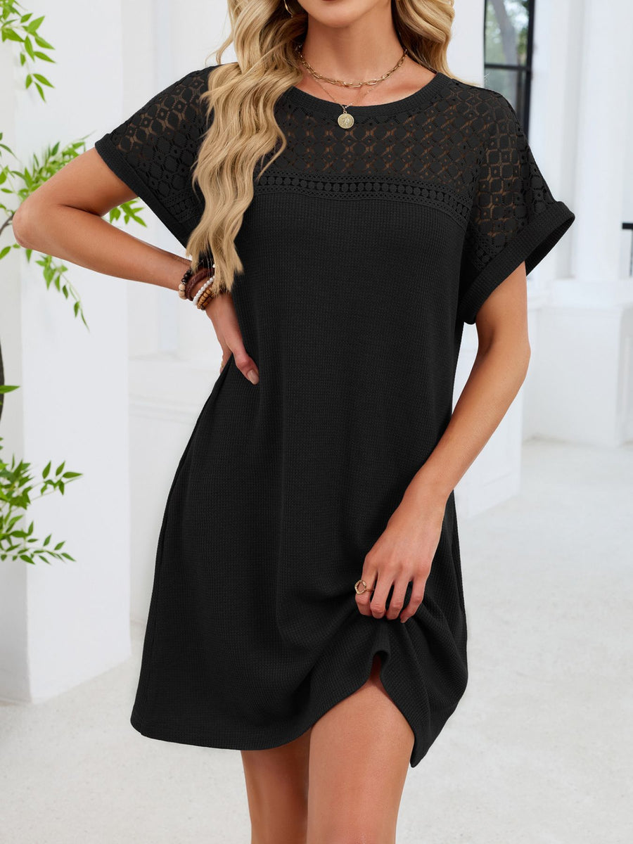 Black t-shirt dress with sheer lace yoke and short sleeves, above the knee length.