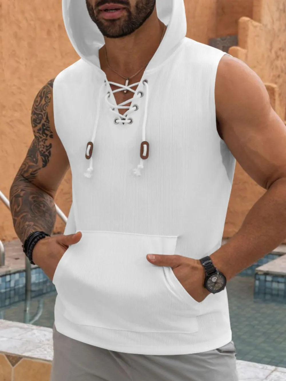 White sleeveless ribbed knit hoodie with lace-up neckline and front pocket.