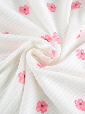 White ribbed knit fabric with pink floral print, detail shot