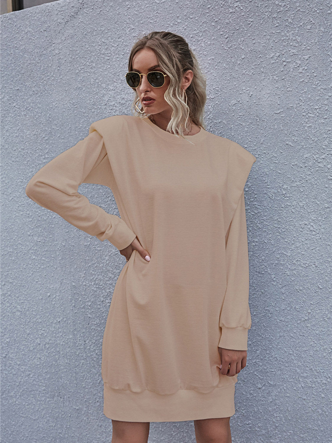 Tan sweatshirt mini dress with padded shoulders and long sleeves.