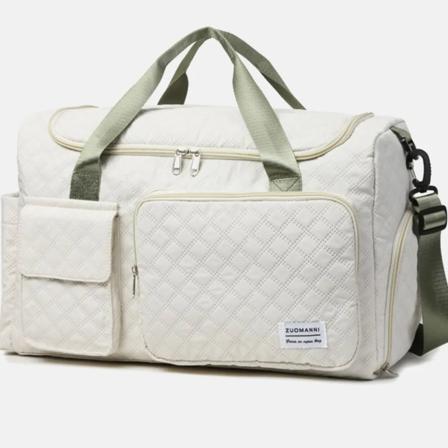 White quilted duffel bag with olive green straps and accents, featuring multiple pockets.