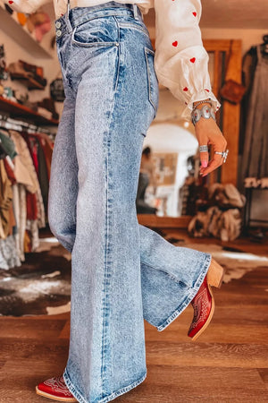 Light wash denim wide leg jeans with a high waist and distressed details.