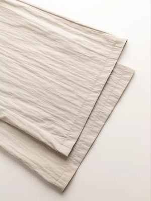 Beige wide-leg pants with textured fabric and visible stitching detail
