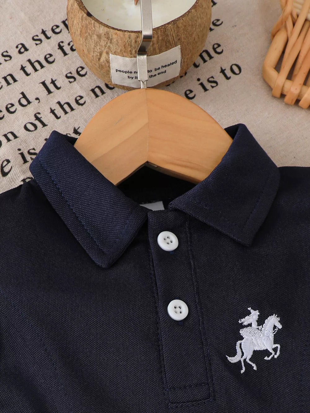 Navy polo dress with white horse embroidery and ruffled hem detail.