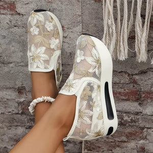 White floral embroidered mesh slip-on sneakers with a chunky platform sole.