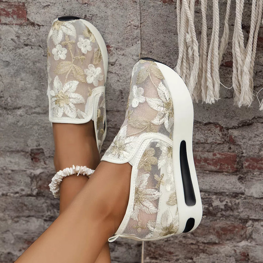 White floral embroidered mesh slip-on sneakers with a chunky platform sole.