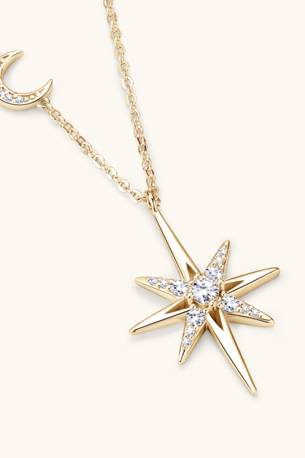 Gold celestial starburst pendant necklace with cubic zirconia and a crescent moon charm.