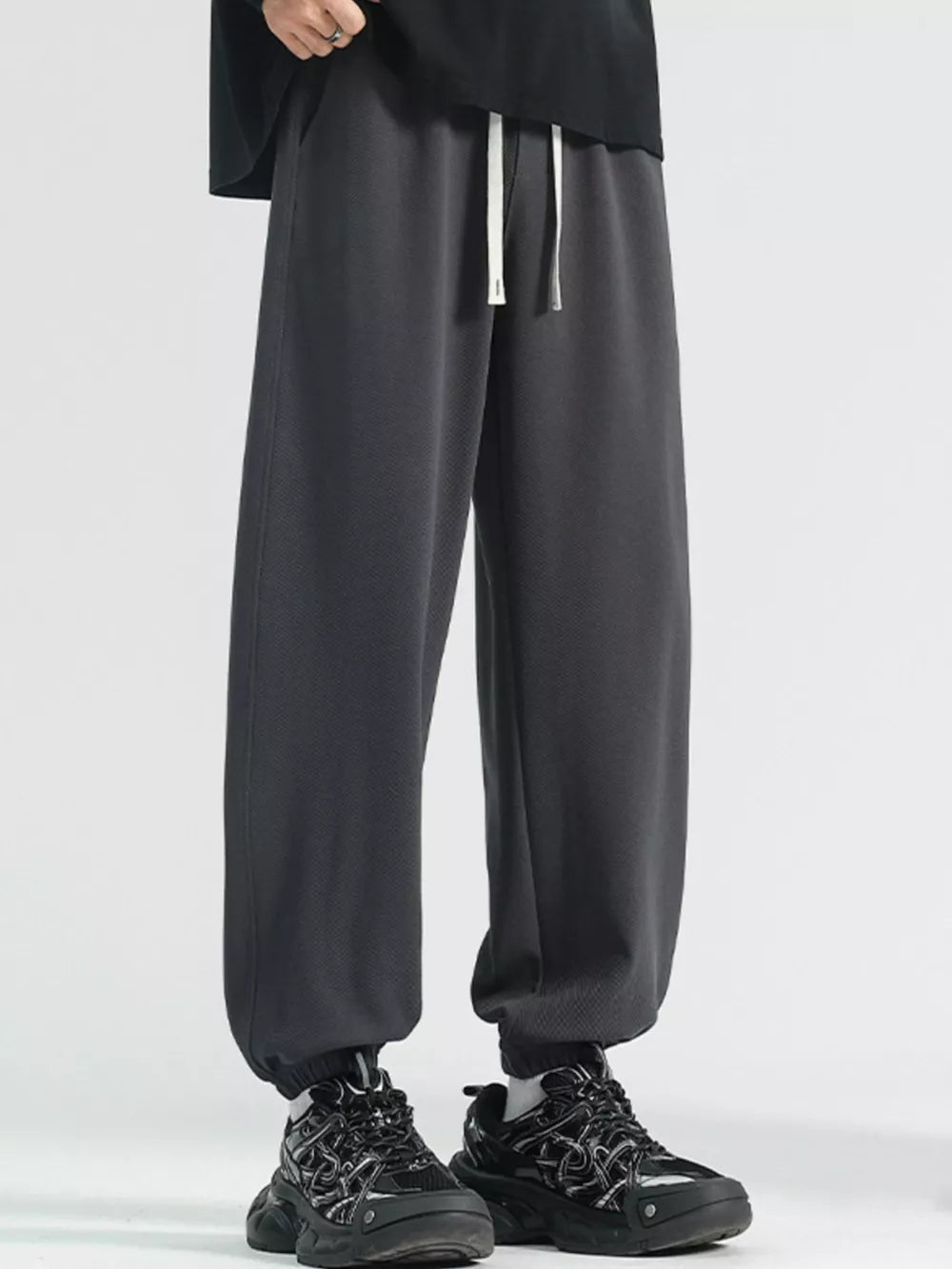 Men's dark gray loose fit sweatpants with drawstring and cuffed ankles