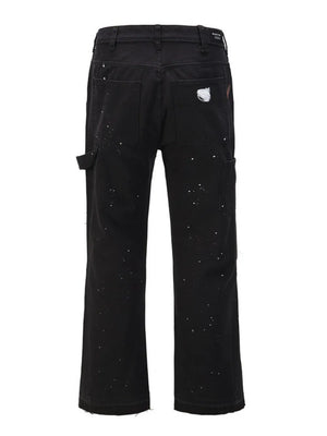 Black carpenter trousers with white paint splatters and distressed detail.
