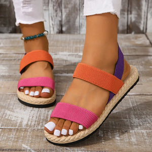 Rope-sole cross-strap sandals in orange, pink, and purple with elastic straps.